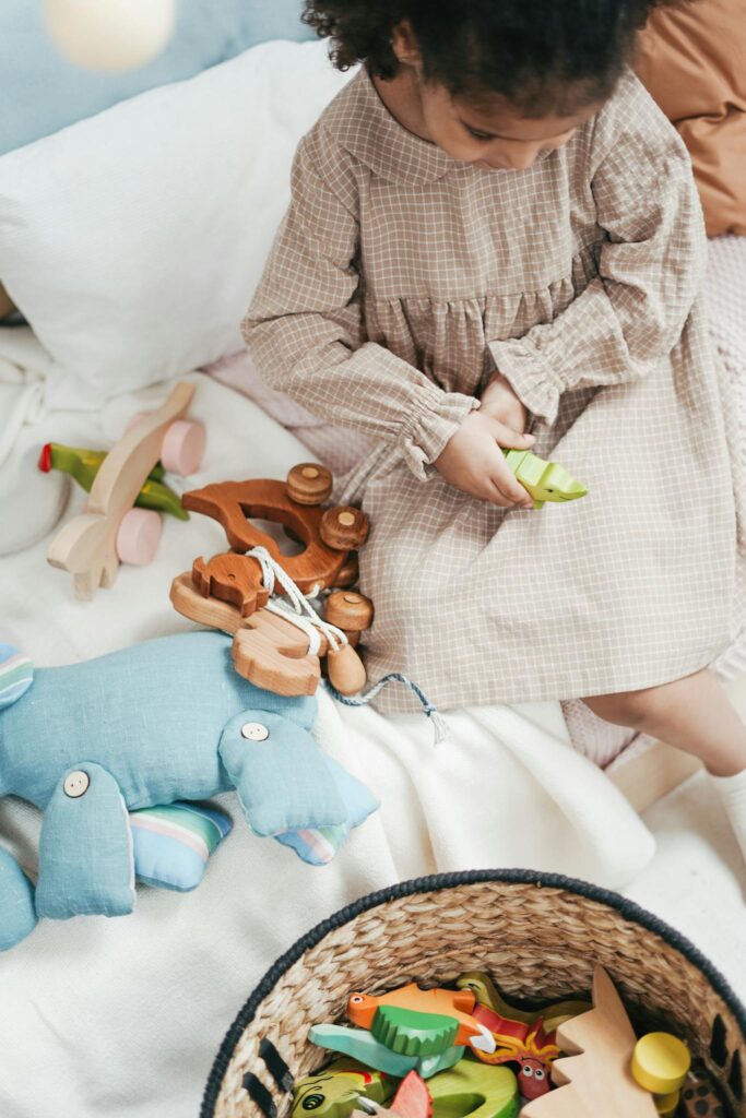 Person in Brown and White Checkered Dress Holding Wooden Toy